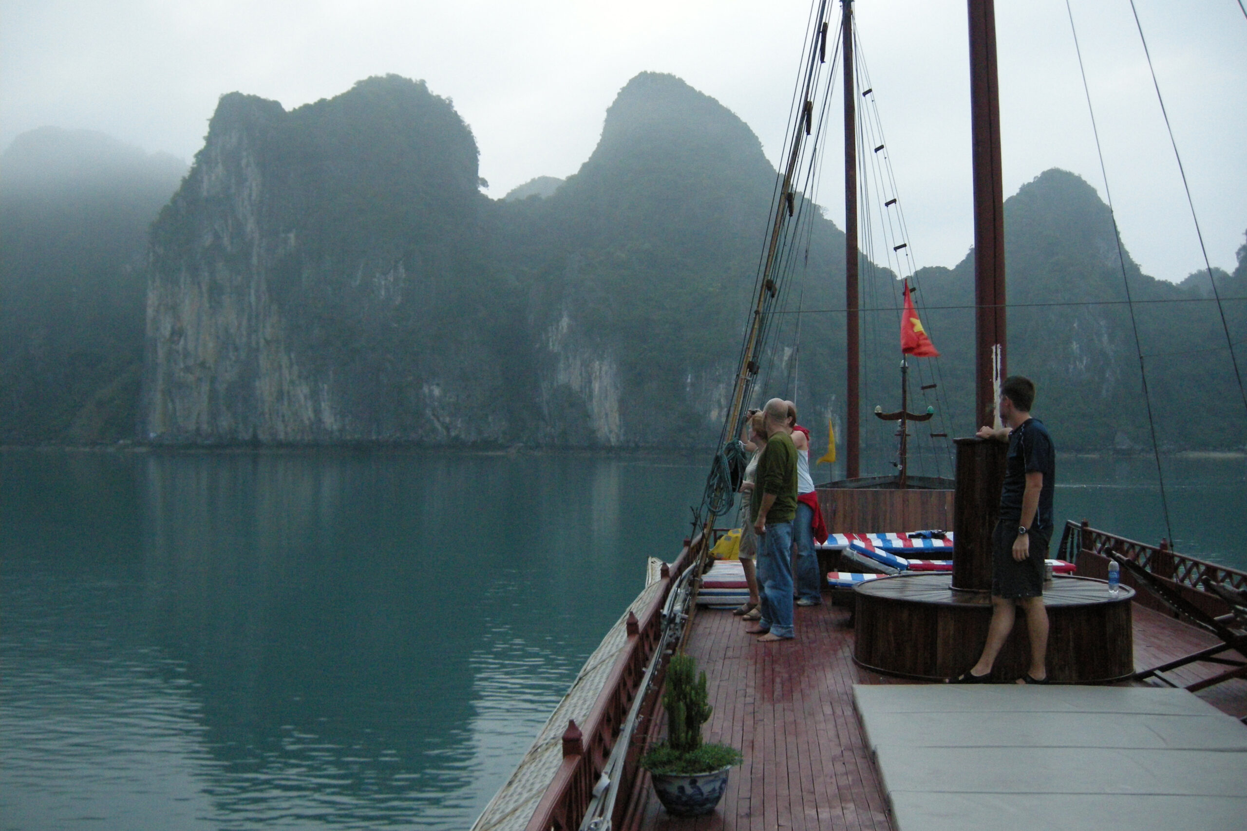 Ha Long Bay cruise boat wooden junk vessel sailing between limestone karst islands
