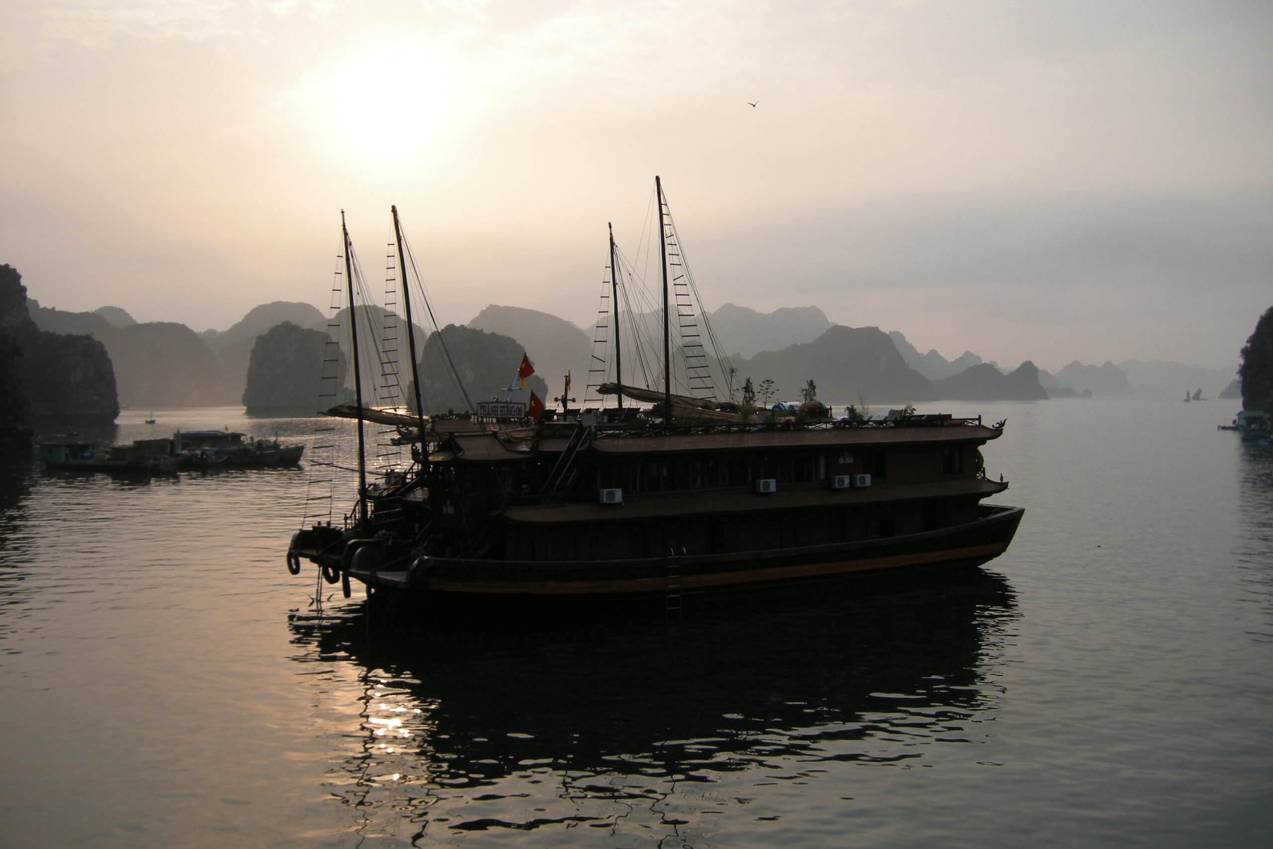 Ha Long Bay Vietnam sunset golden hour limestone karsts silhouette traditional boat